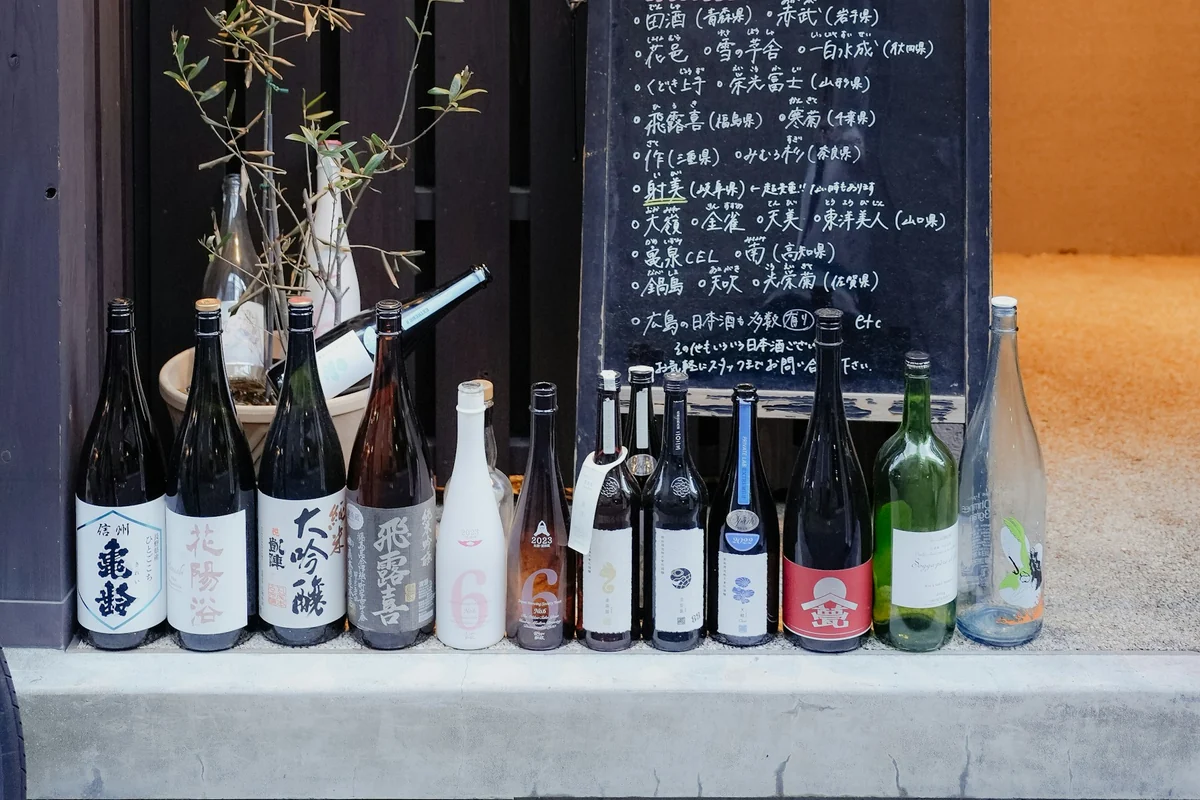 Sake bottles displayed outside a Japanese restaurant at night